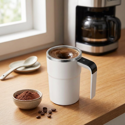 White travel mug with handle filled with coffee on a wooden surface next to a coffee maker and bowl of coffee beans.