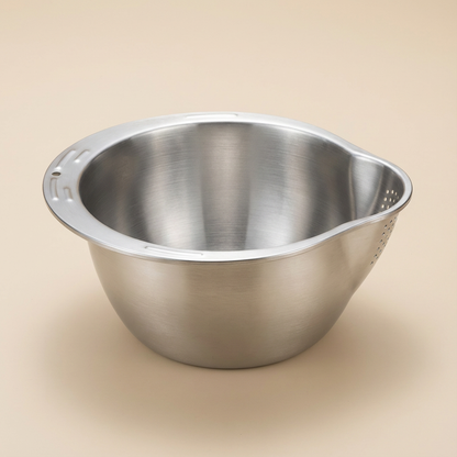 Stainless steel mixing bowl on a beige background