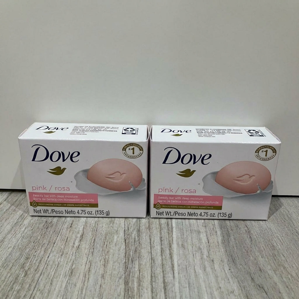 Two boxes of Dove pink soap on a light wooden surface with a white background