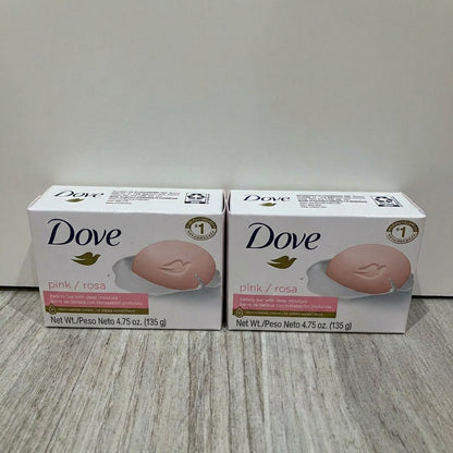 Two boxes of Dove pink soap on a light wooden surface with a white background