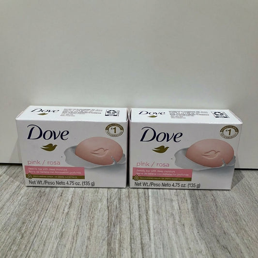 Two boxes of Dove pink soap on a light wooden surface with a white background