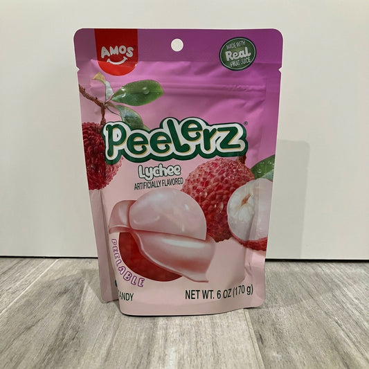 Pink package of Amos Peelerrz Lychee candy on a wooden surface with a white background